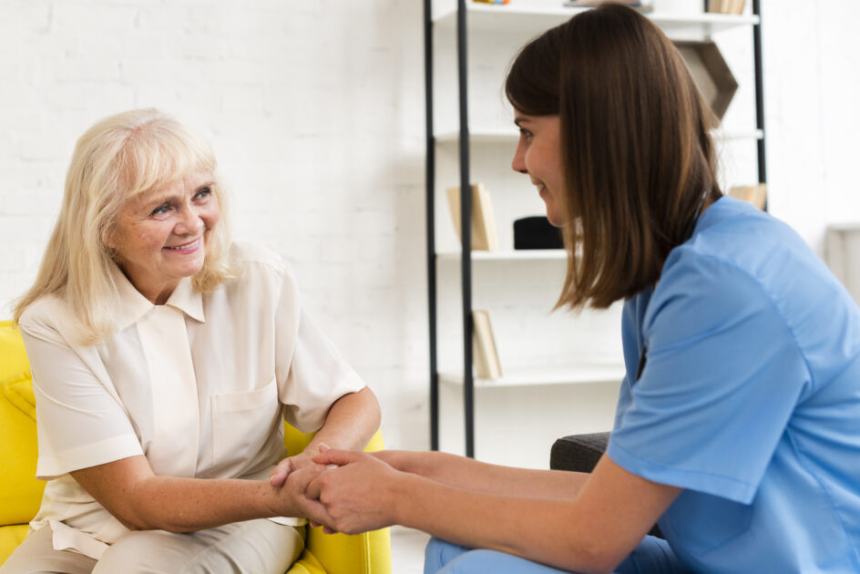 medium shot old woman and nurse holding hands
