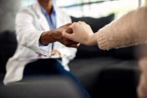 plan rapproche du psychotherapeute et de son patient tenant des mains pendant une session