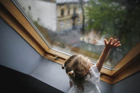 petite fille regarde par la fenetre