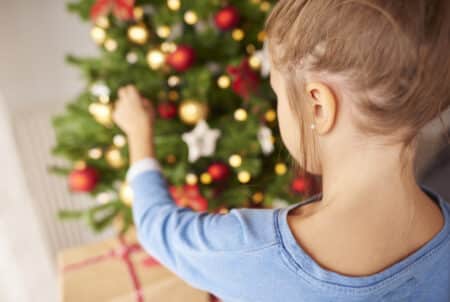 petite fille decorant le sapin de noel