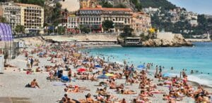 belle vue generale d'une plage de Nice avec beaucoup de touristes en plein été