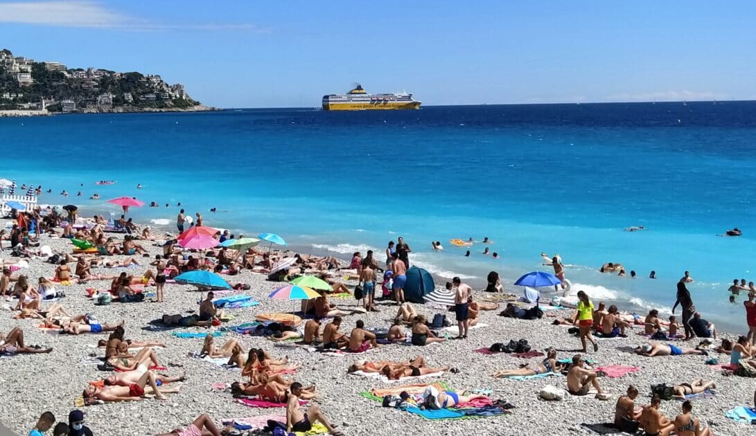 plage de Nice avec touristes et bateau de la corsica ferries