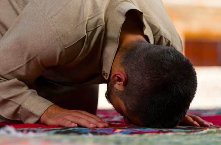 Jeune fidèle musulman priant contre le sol d'une mosquée